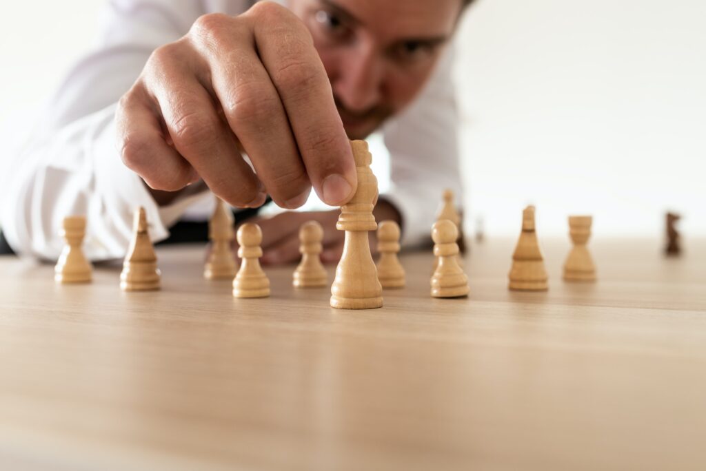 Business leader arranging chess pieces with king in the leading position